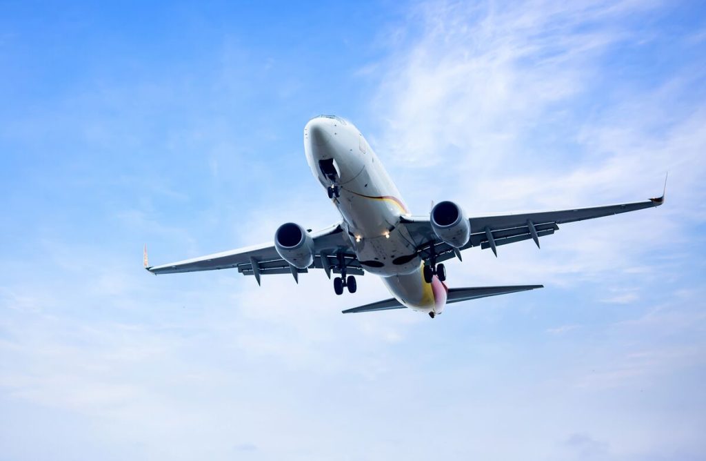 Passenger jet climbing into a blue sky